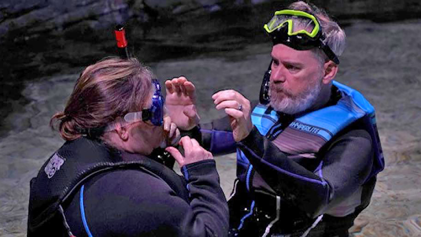 Vet adjusts goggles before swimming with stingrays