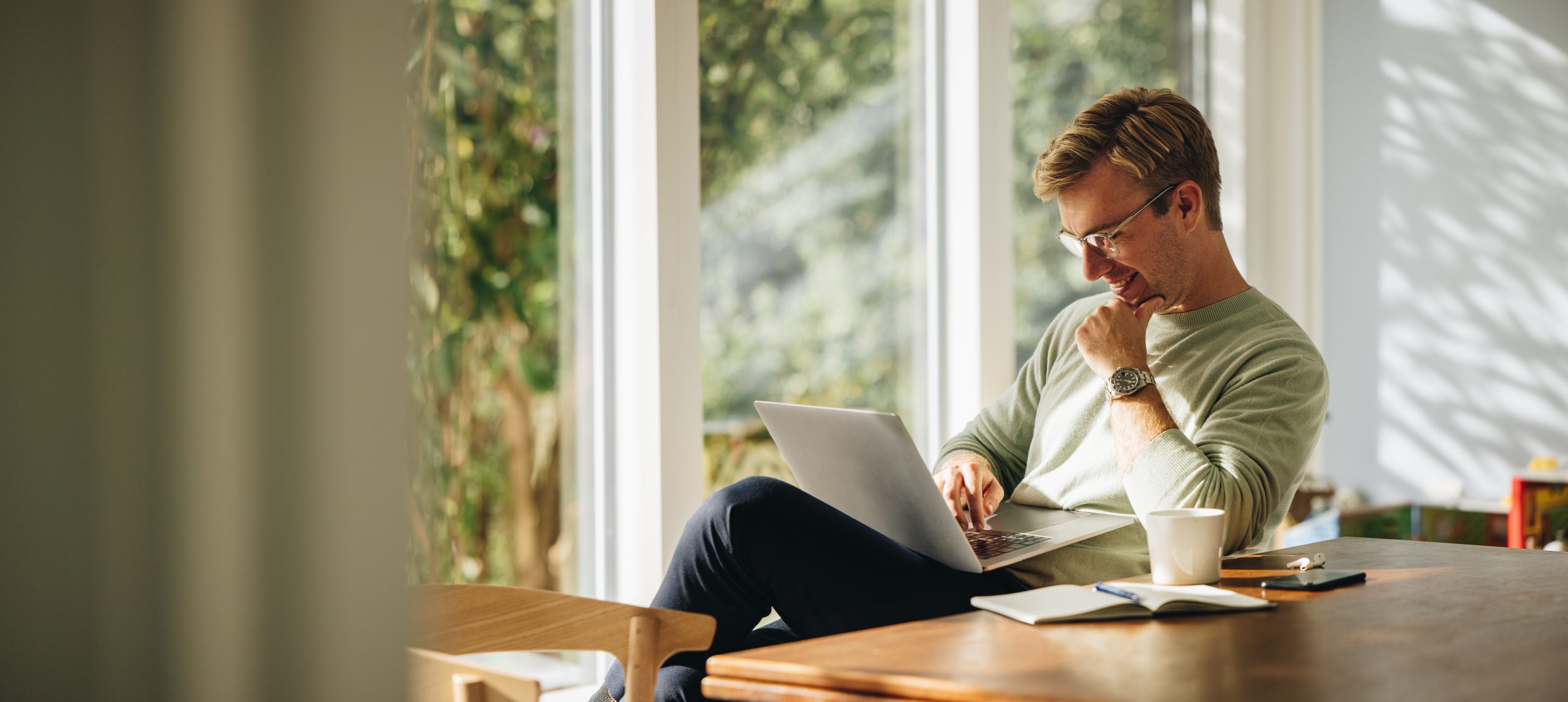 Man using his laptop at the dining room table.