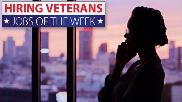 Woman looking out window of high rise building. Jobs of the week for veterans.