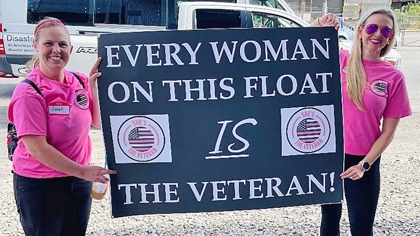 Women holding sign; she’s the veteran