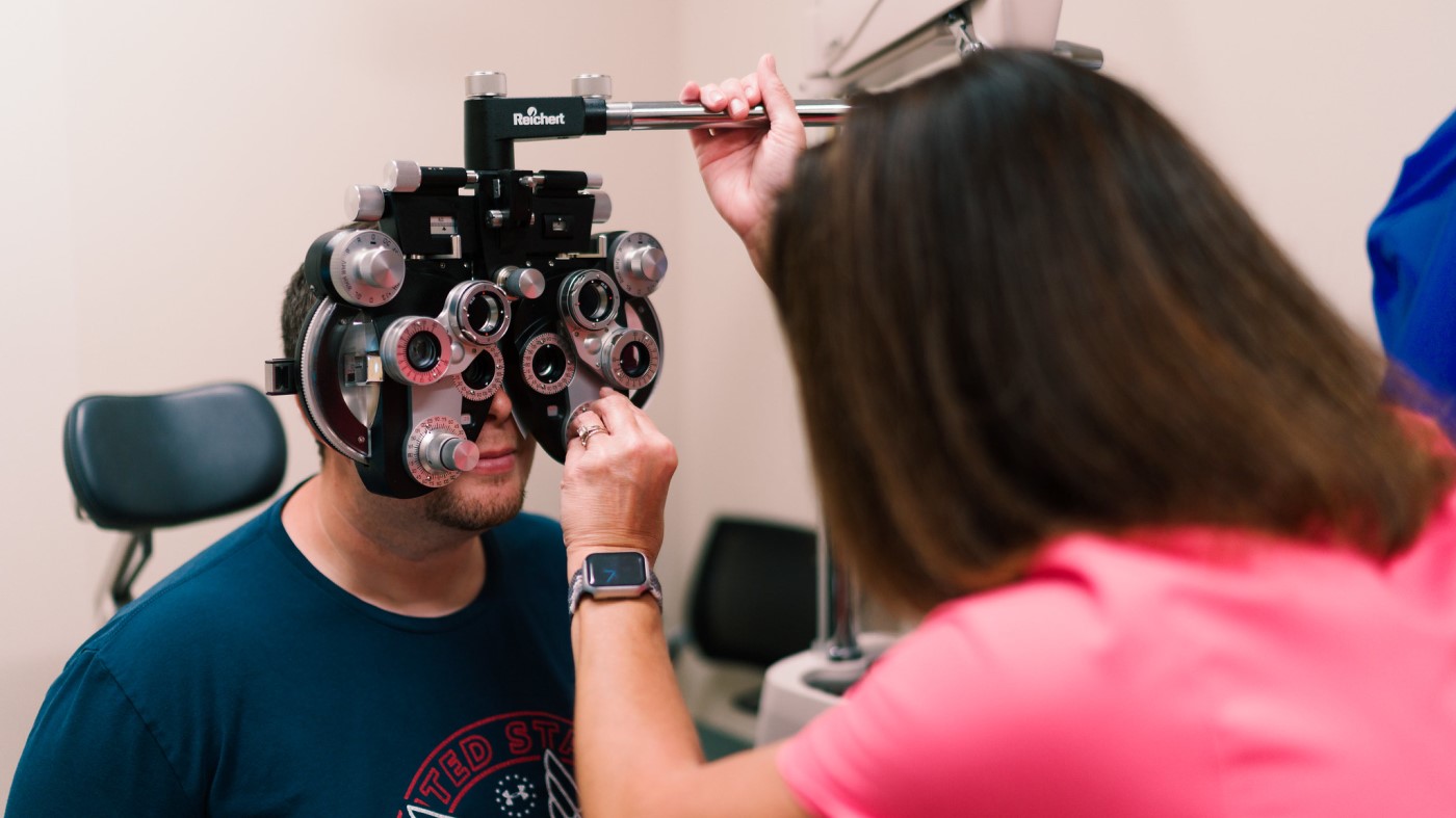 A VA optometrist uses exam equipment to check a Veteran’s vision.