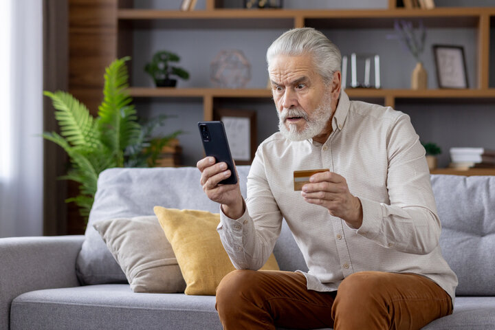 Male looking phone with worried look