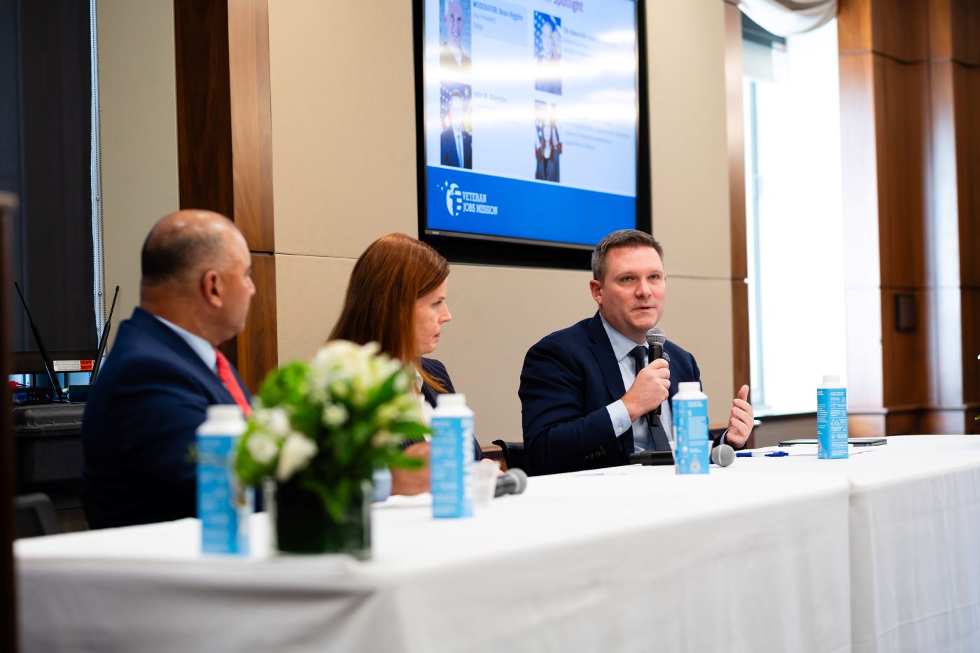 Three people sitting on stage at a panel discussion.