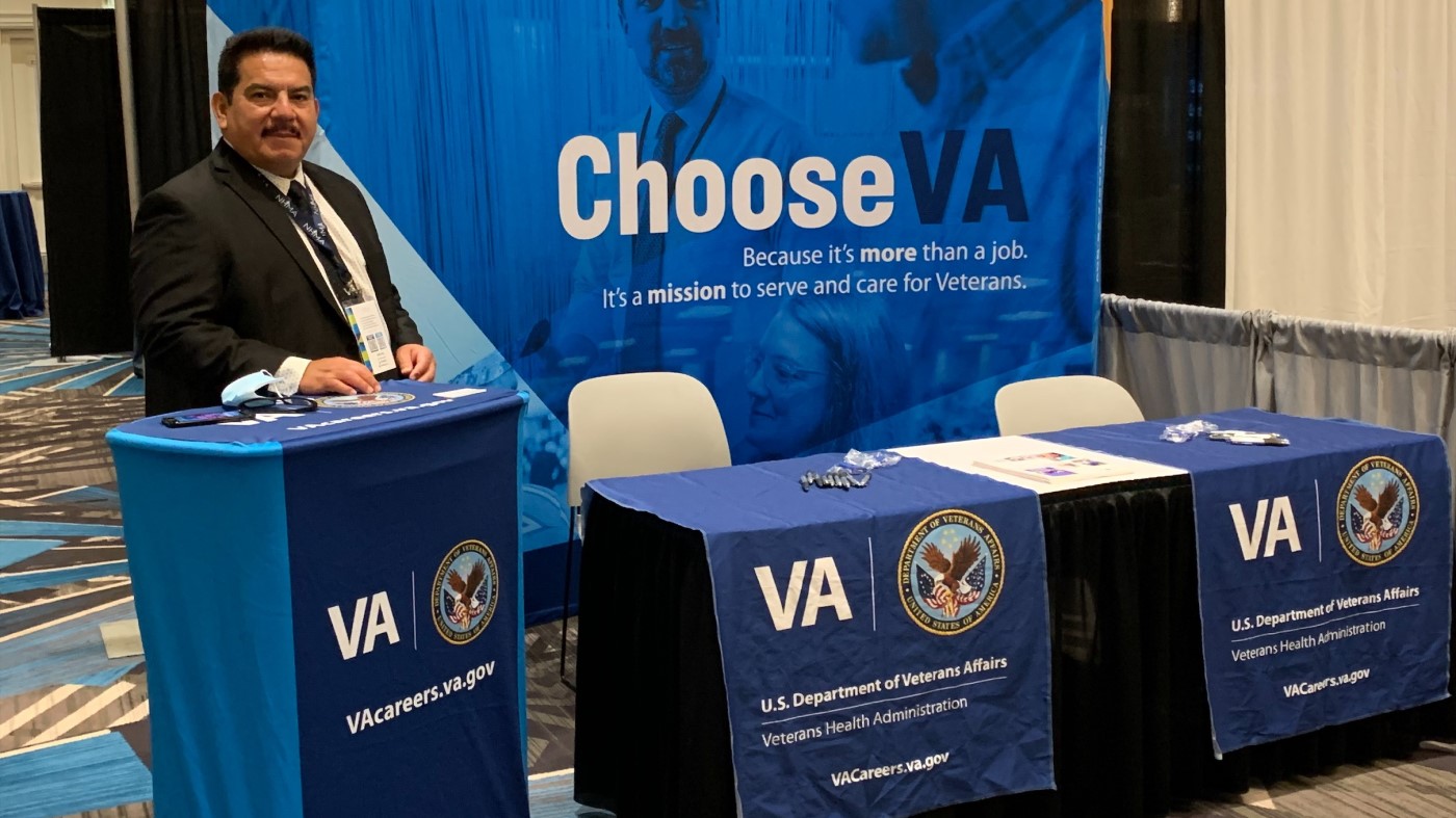 A VA recruiter stands at a booth at one of the national events we attend.