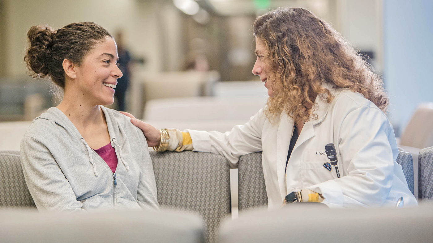 Two women talking in a waiting room; community partnership