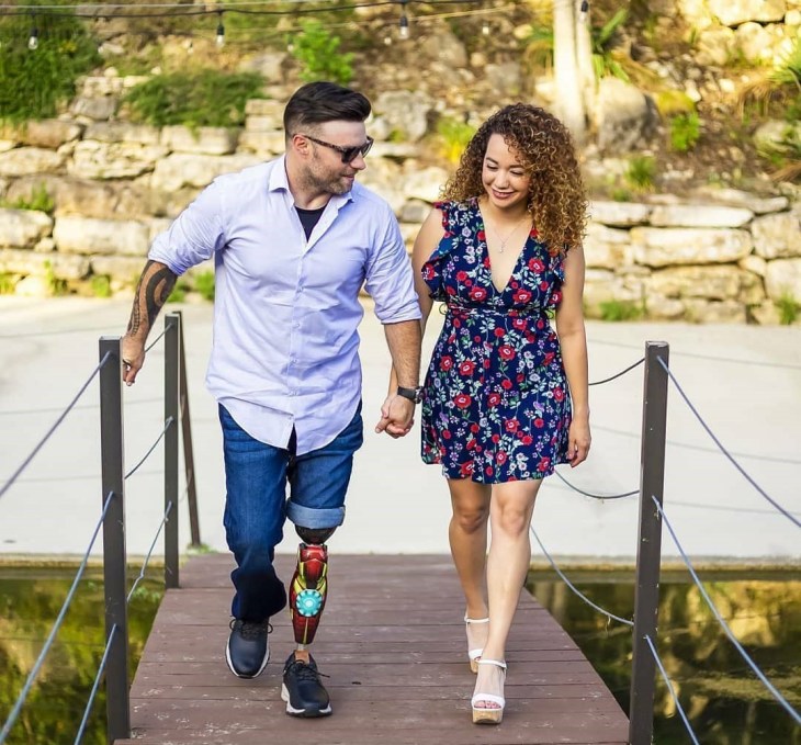 Man with prosthetic leg and woman walking together hand-in-hand.