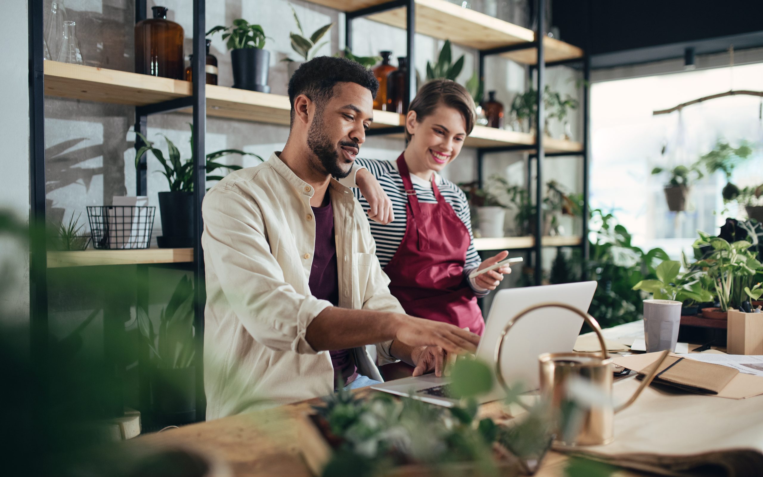 A man and woman small business owners working in a flower shop.