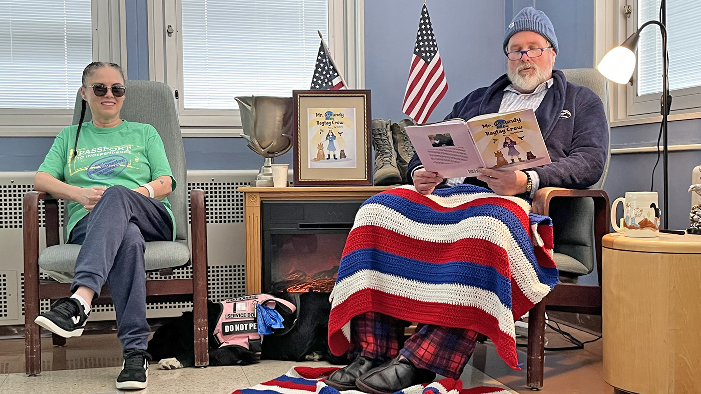 A man reads a story as a woman sits nearby